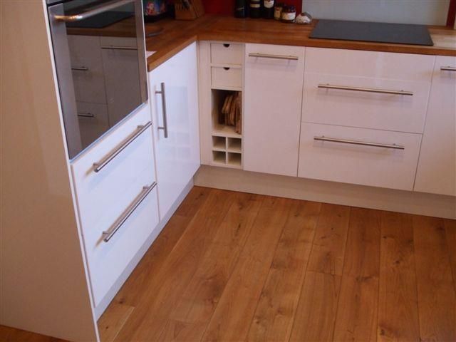 Eine Küche mit weißen Schränken und Holzböden