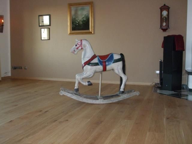 Ein Schaukelpferd sitzt auf einem Holzboden in einem Wohnzimmer