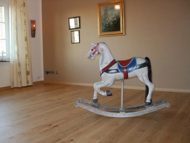Ein Schaukelpferd in einem Raum mit einem Bild an der Wand