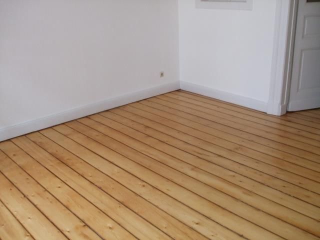 Ein Raum mit Holzboden und weißen Wänden