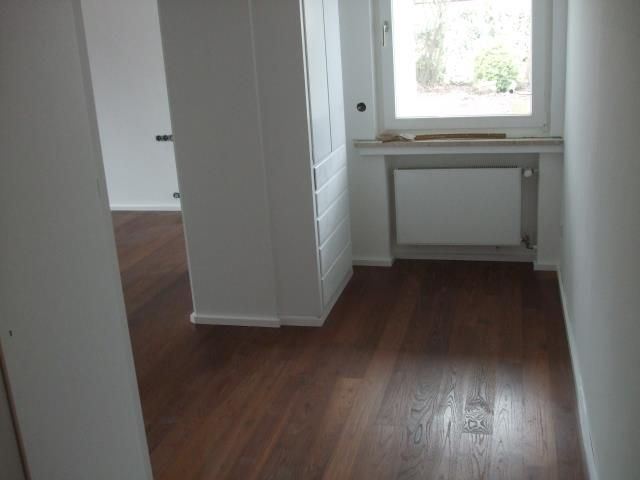 Ein Flur mit Parkettboden und Fenster