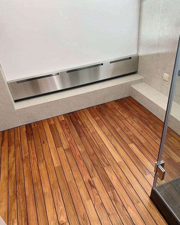 Ein Badezimmer mit Holzboden und einer Edelstahlbank