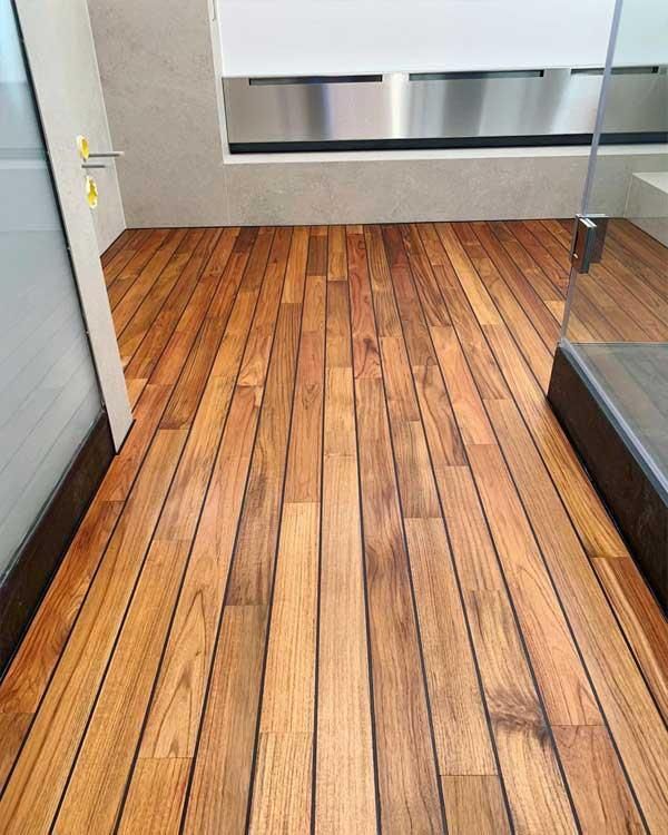 Ein Badezimmer mit Holzboden und Edelstahlwaschbecken.