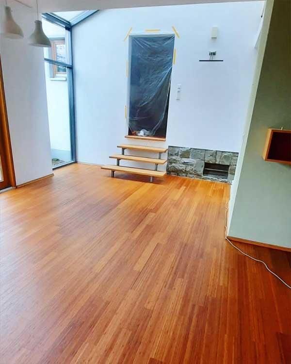 Ein leerer Raum mit Holzboden und Holztreppe.