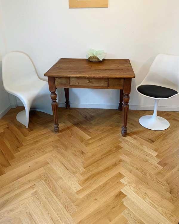 Ein Holztisch und Stühle stehen auf einem Holzboden.