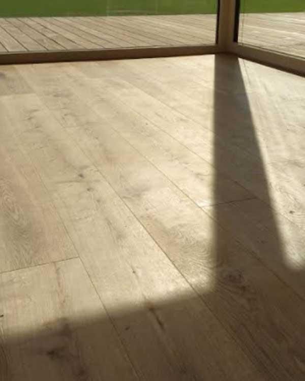 Eine Nahaufnahme eines Holzbodens mit einem Schatten darauf.