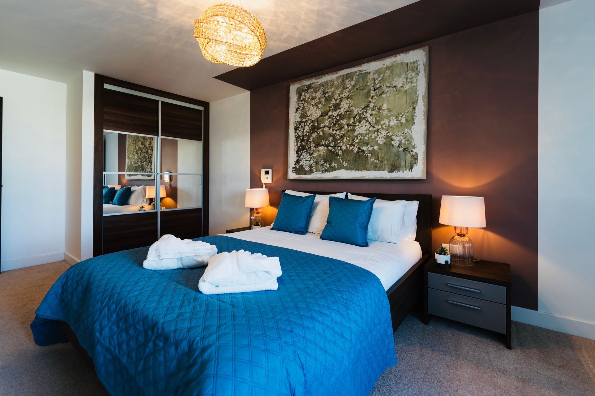 A bedroom with a blue bed and a brown wall