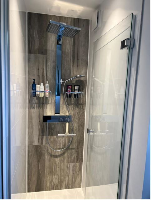 Ein Badezimmer mit Dusche und Glastür.