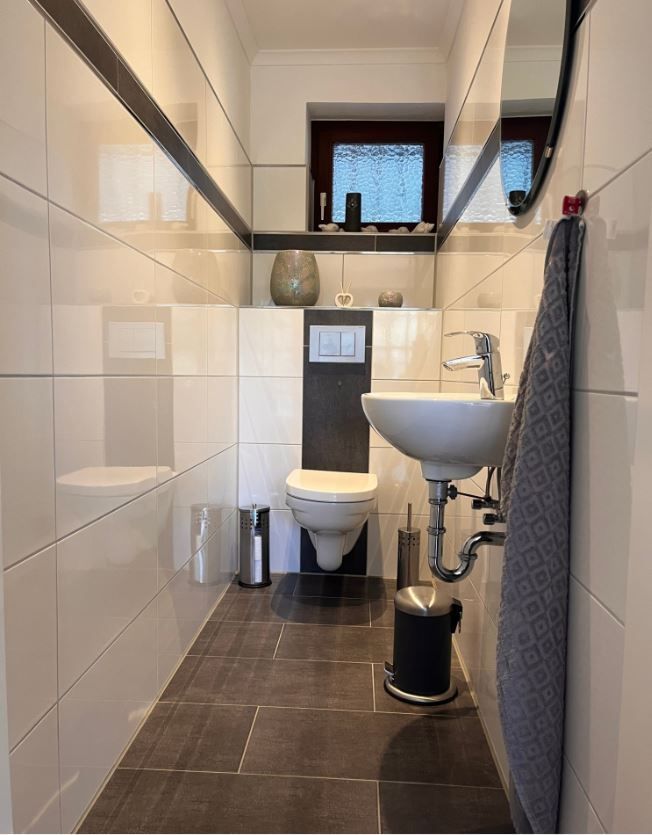 Ein Badezimmer mit Toilette, Waschbecken und Spiegel