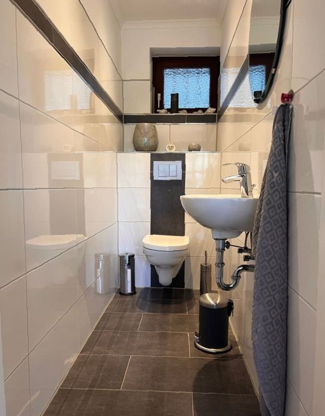 Ein Badezimmer mit Toilette, Waschbecken und Spiegel