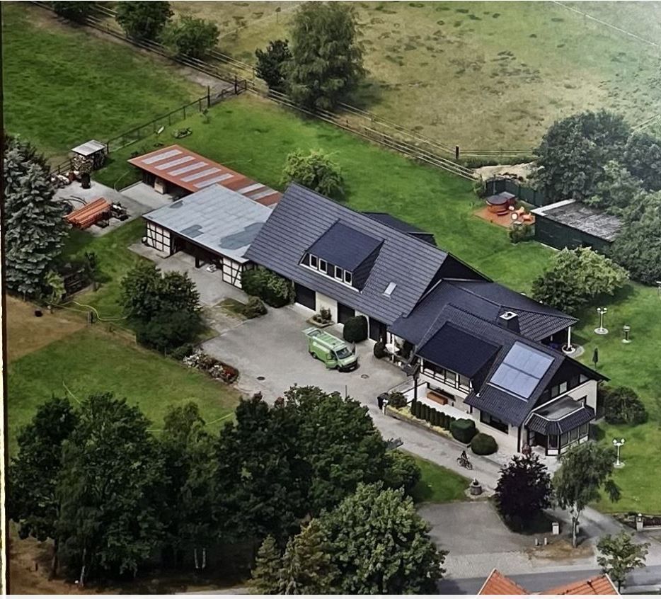 Eine Luftaufnahme eines Hauses, umgeben von Bäumen und Gras