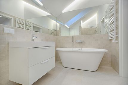 Ein Badezimmer mit Badewanne, Waschbecken und Spiegel.