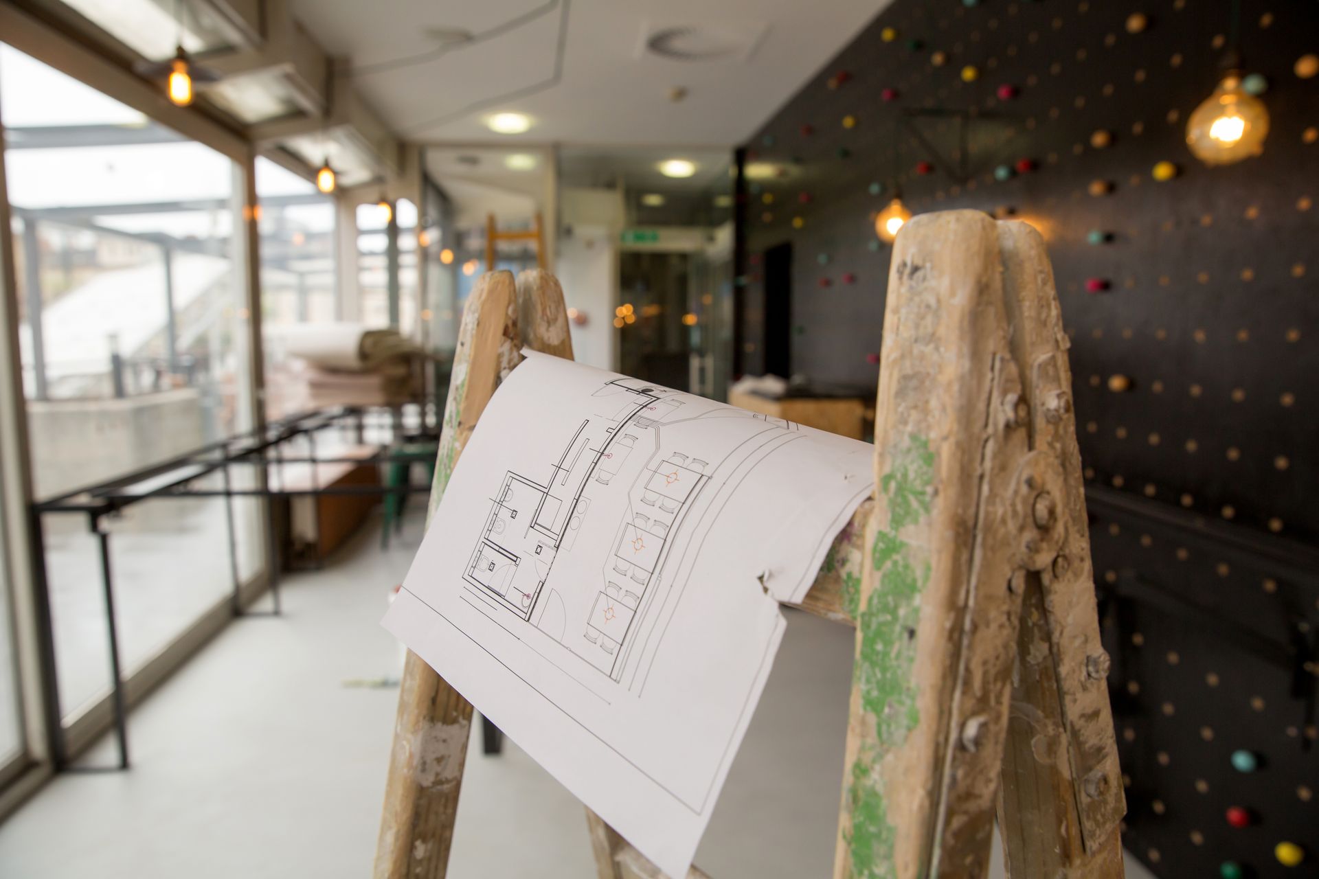 Plan de rénovation posé sur un escabeau en bois clair