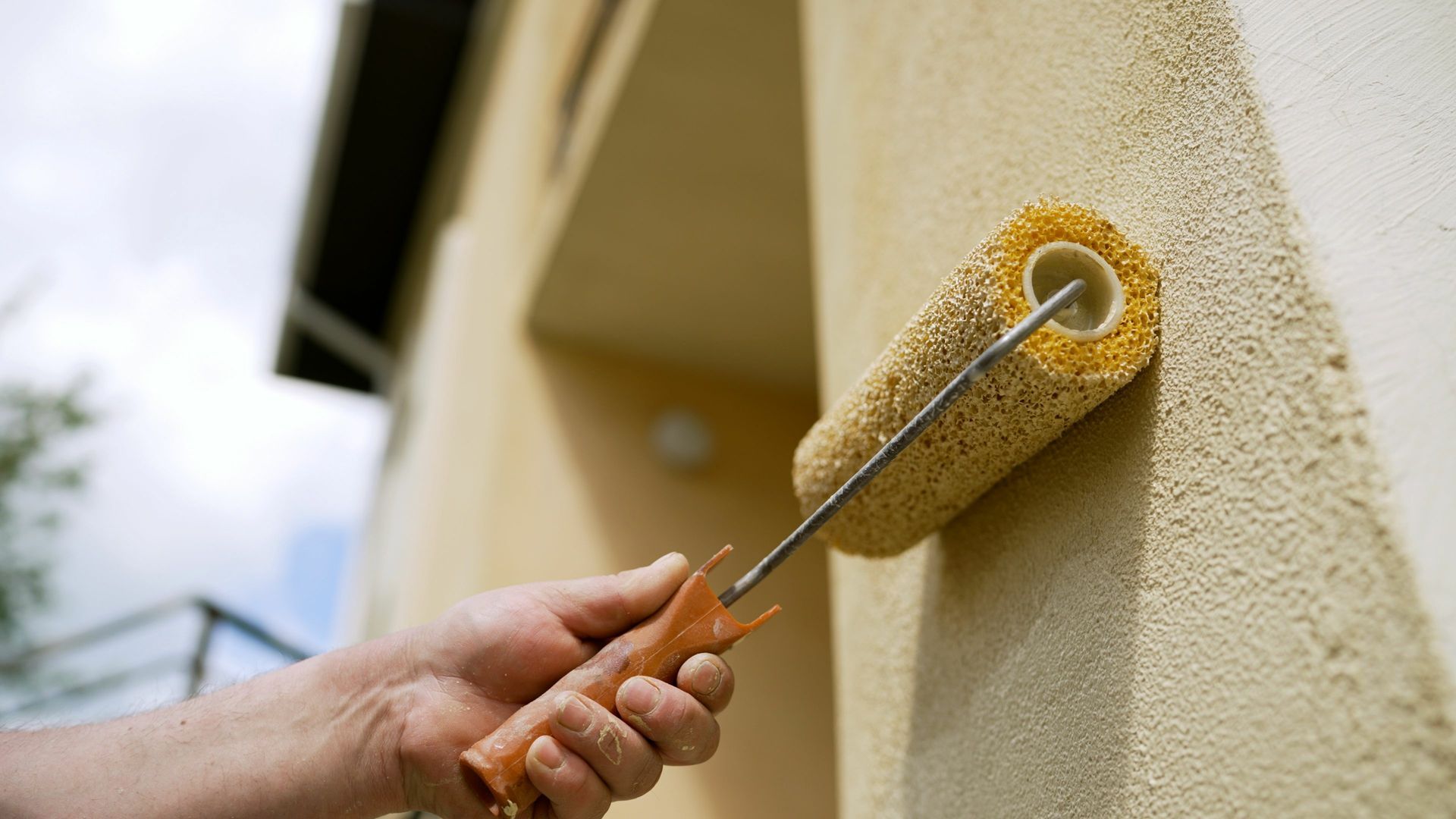 Travaux de peinture sur mur extérieur de maison