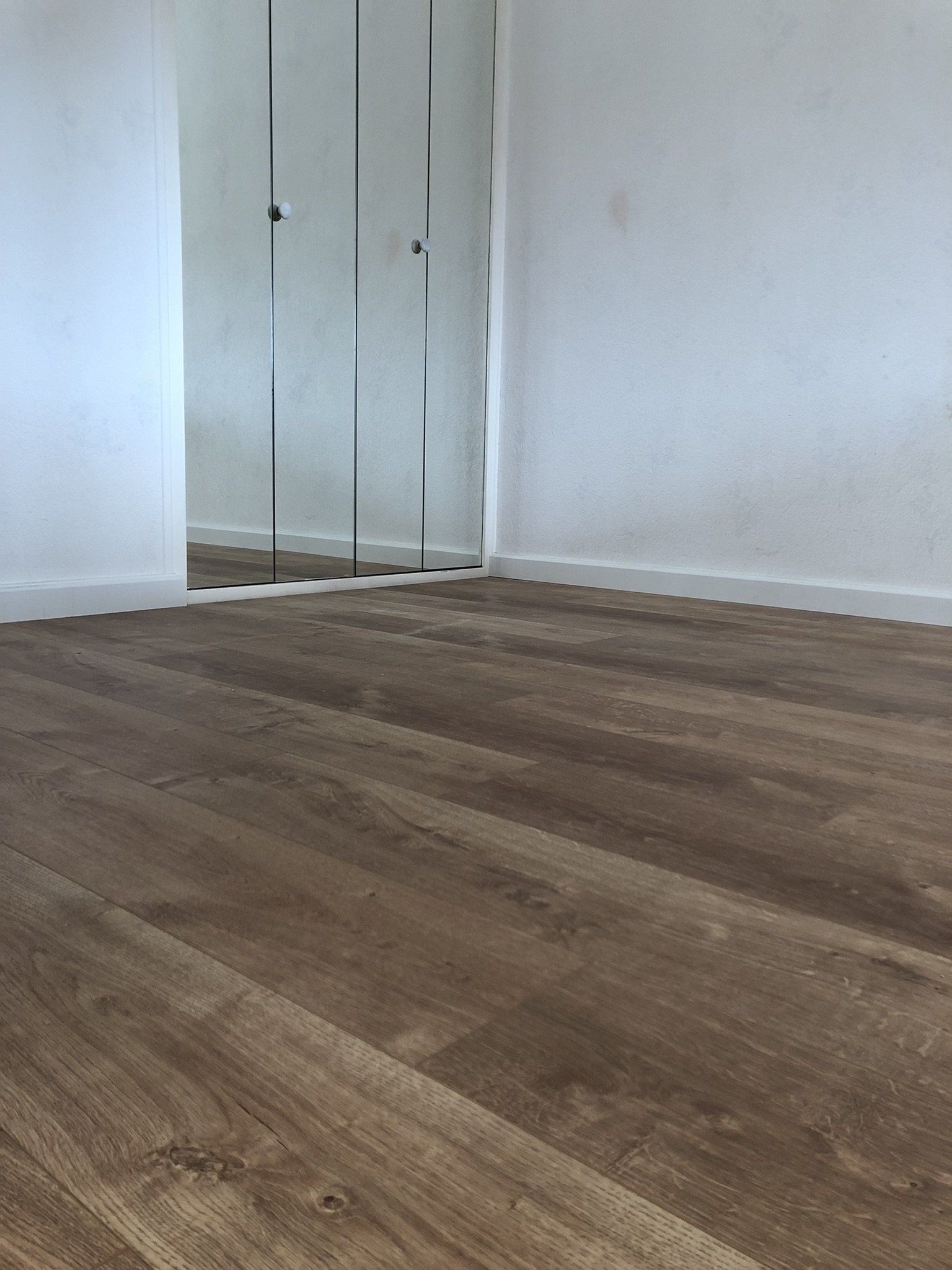 installation de sol stratifié devant une porte avec miroir