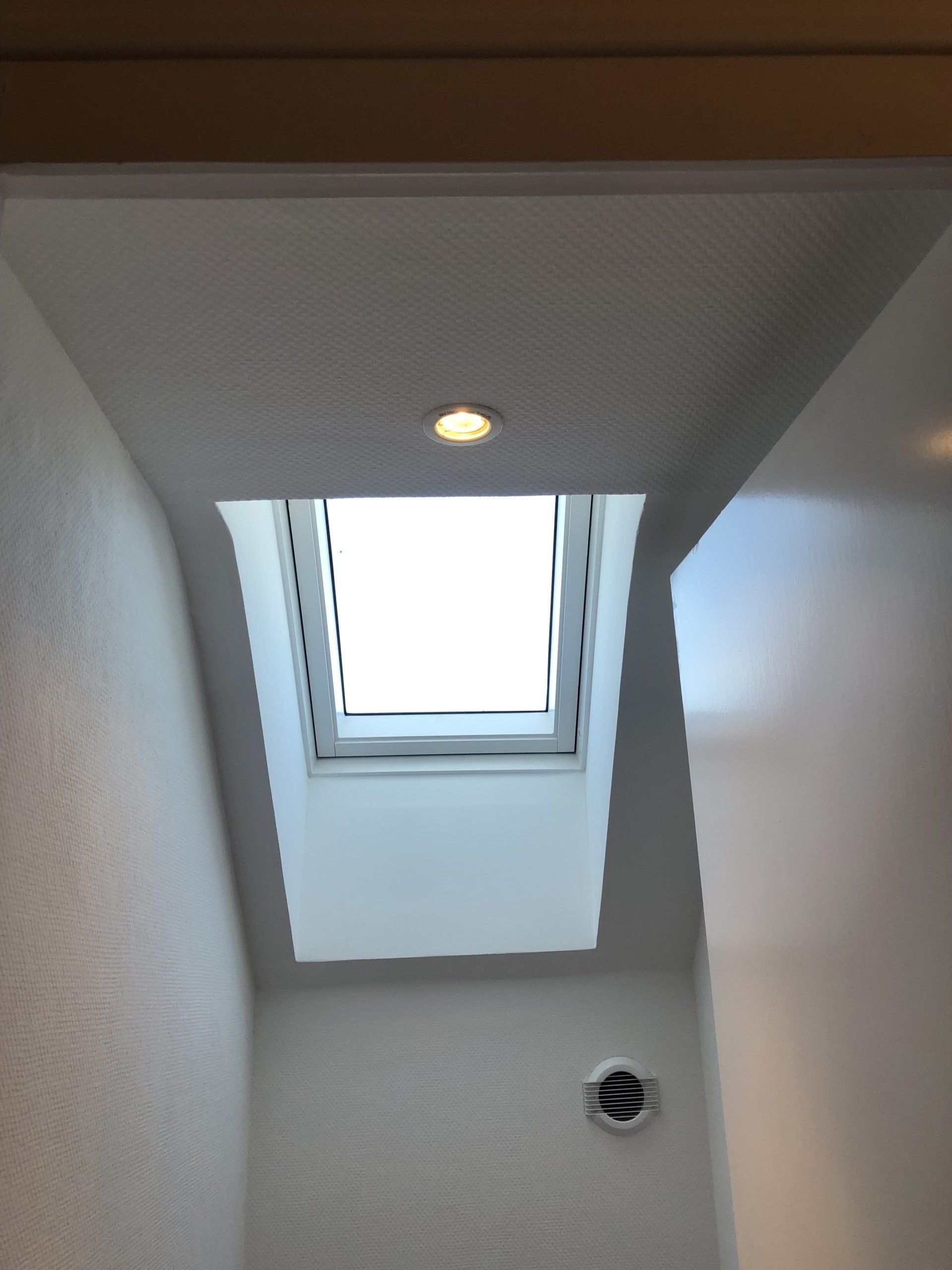 Pose de placo près d'une fenêtre de toit