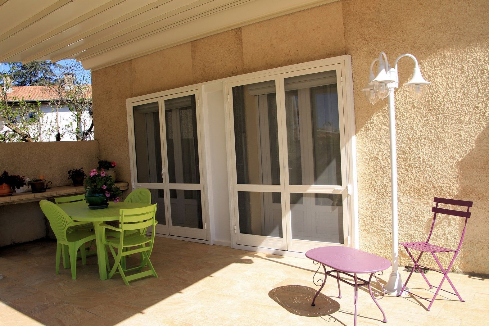 Terrasse sous une pergola avec des tables et des chaises