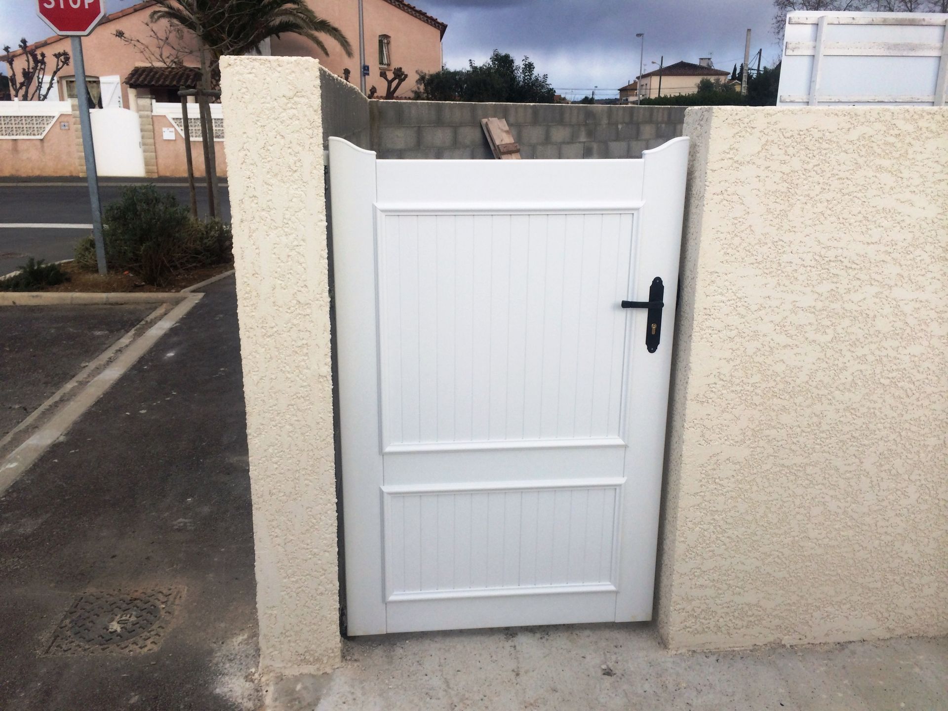 Portillon blanc fixé à un grand muret