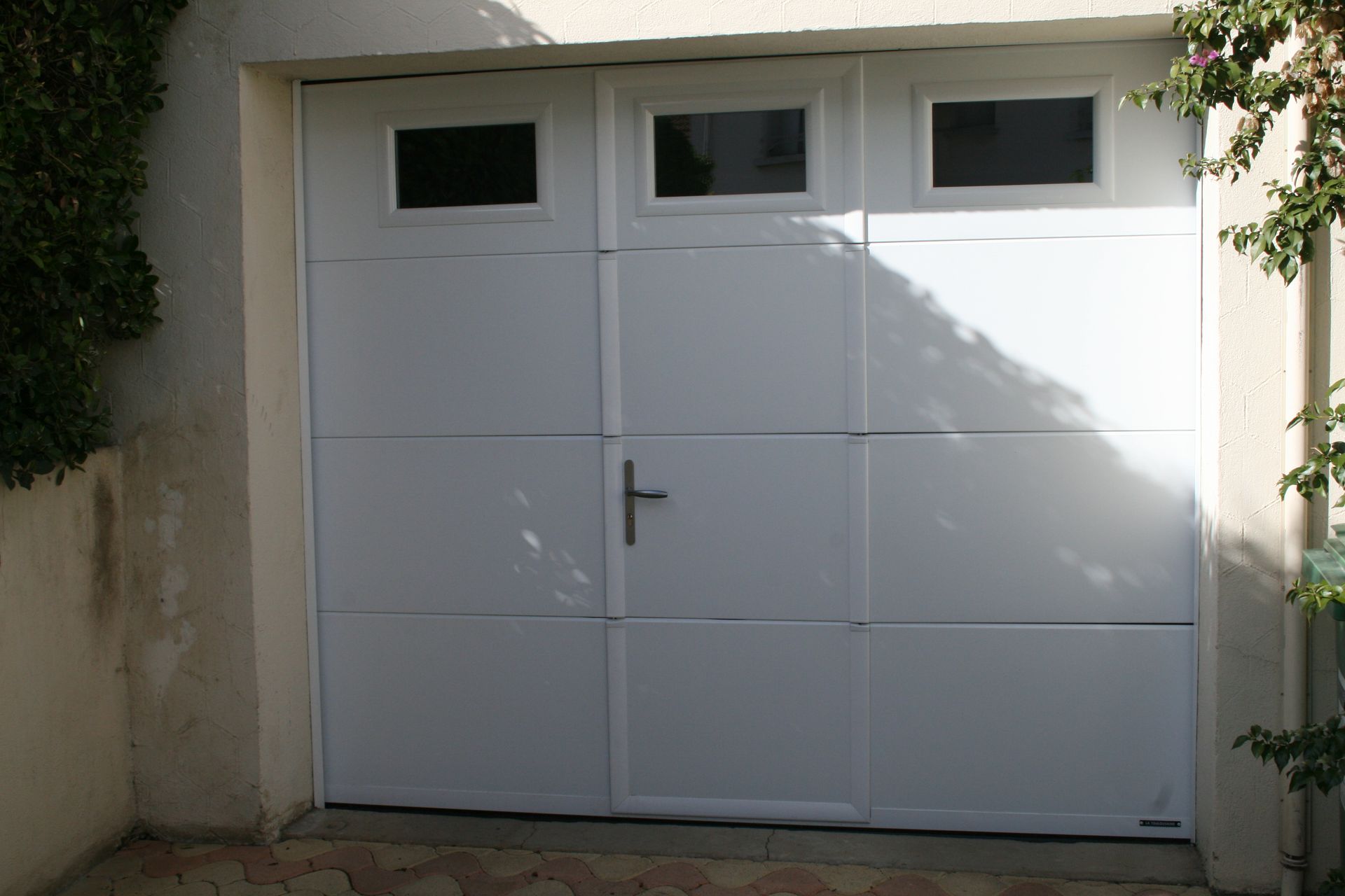 Porte de garage coulissante fermée de couleur blanche