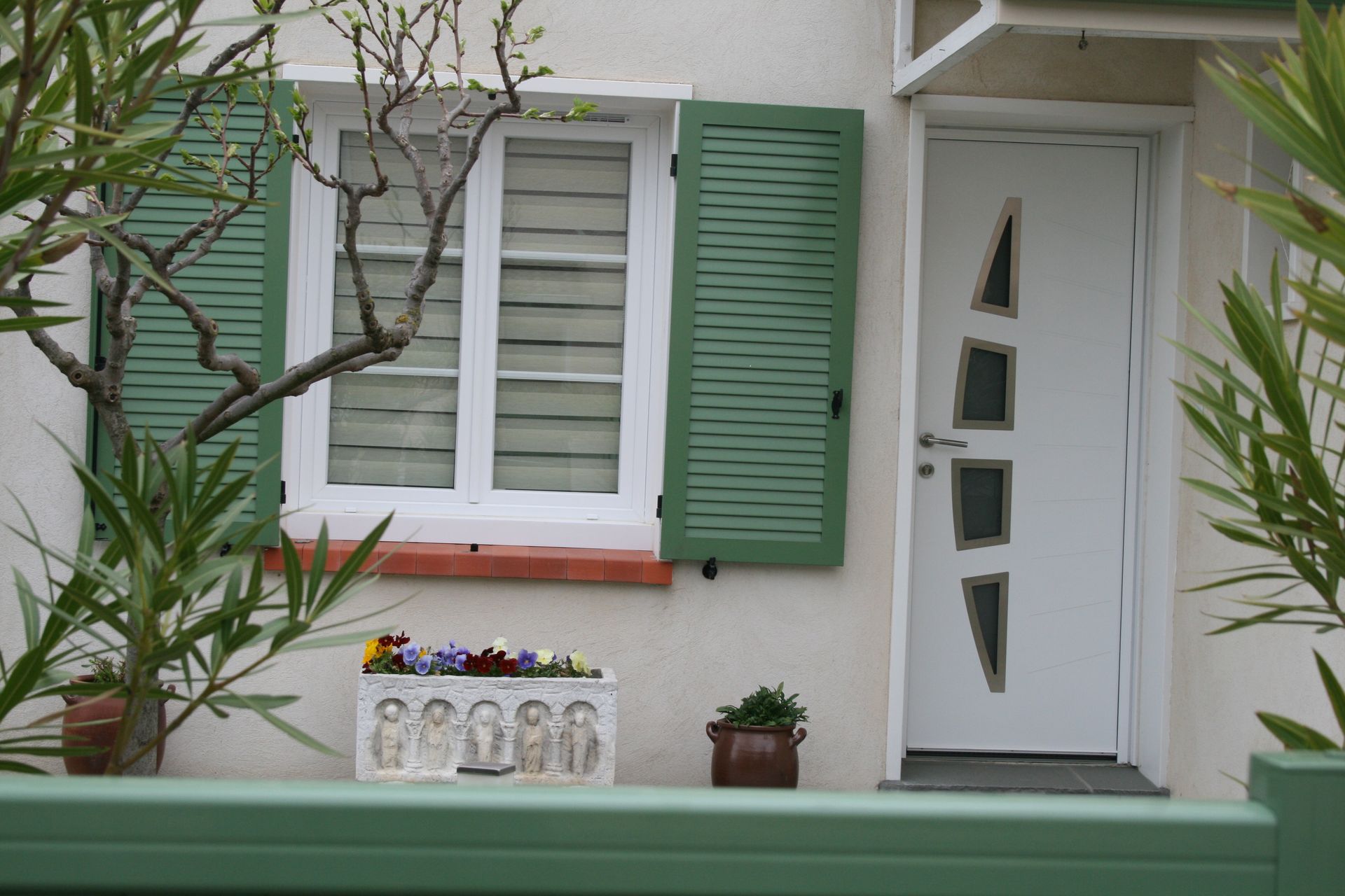 Entrée d'une maison avec des volets verts