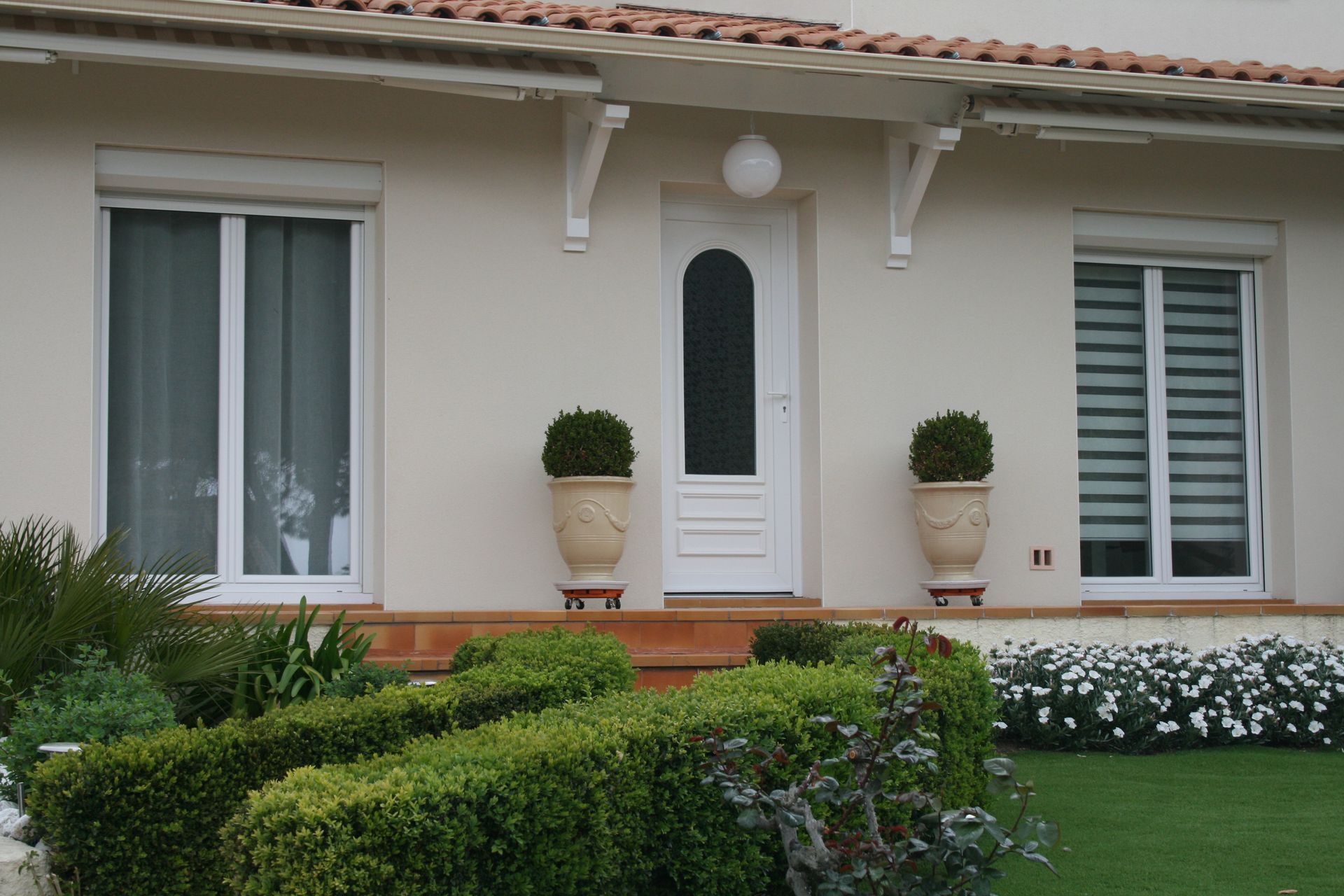 Maison de plain-pied avec une porte-fenêtre et une porte d'entrée en son centre