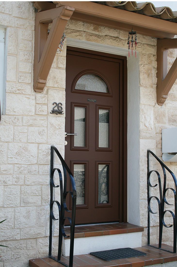 Porte d'entrée en bois marron sombre d'une maison portant le numéro 26