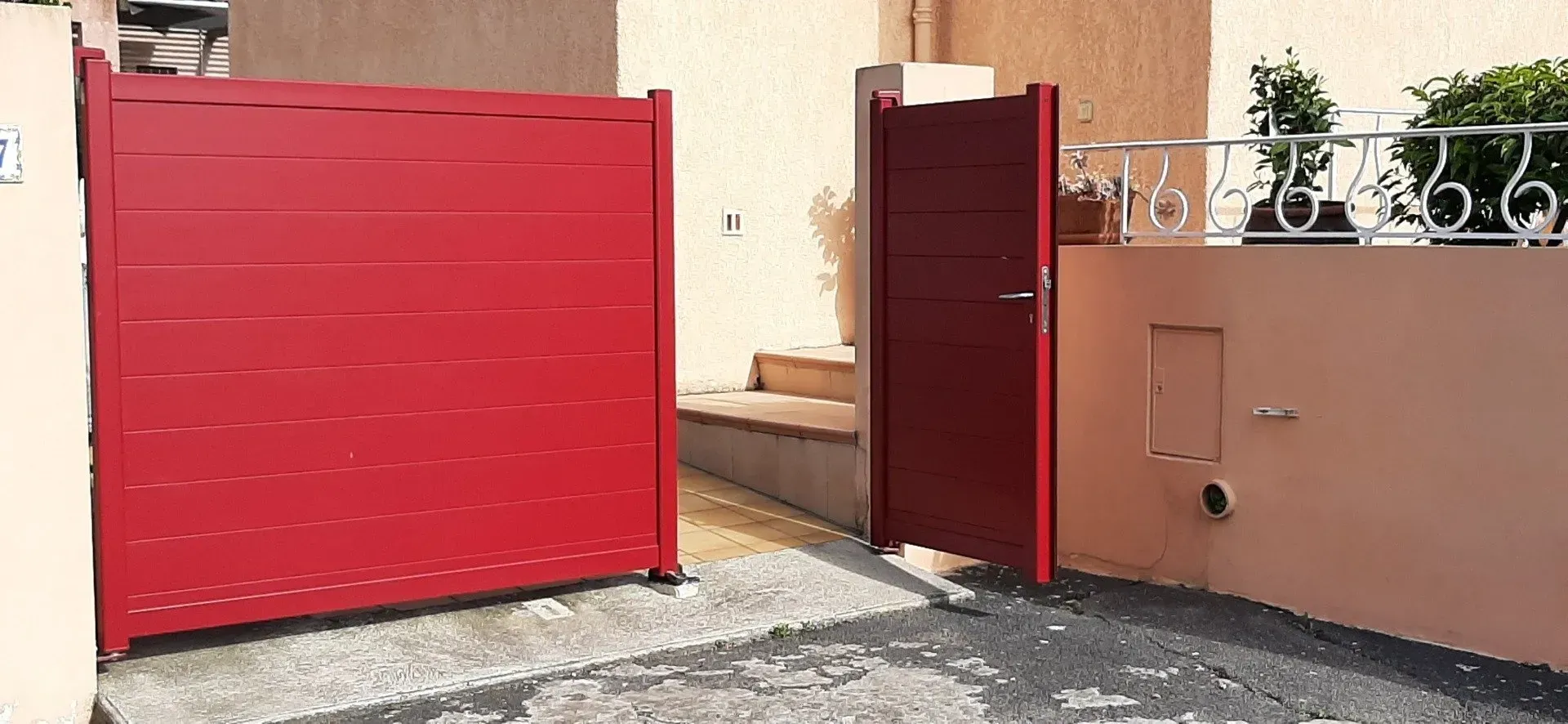 Portillon ouvert d'un portail de couleur rouge