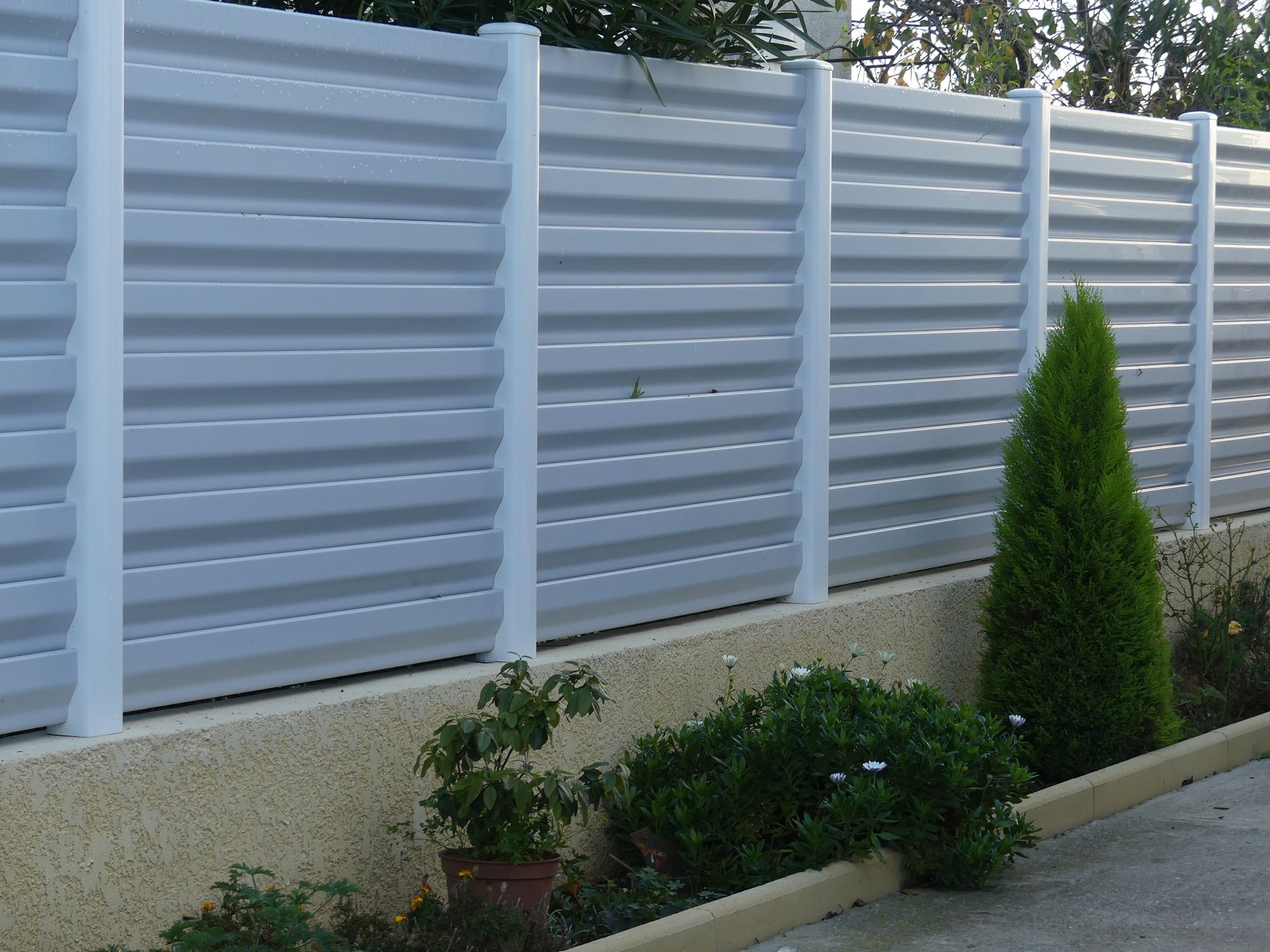 Grande clôture sur un petit muret