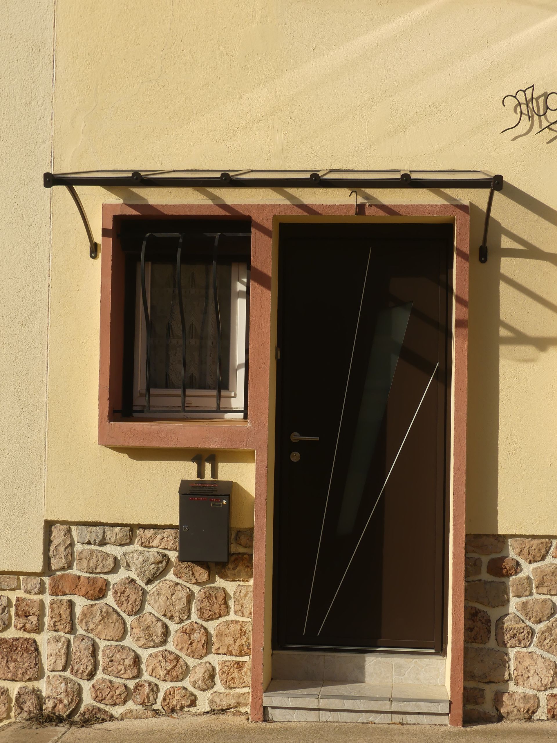 Porte d'entrée et fenêtre avec une marquise