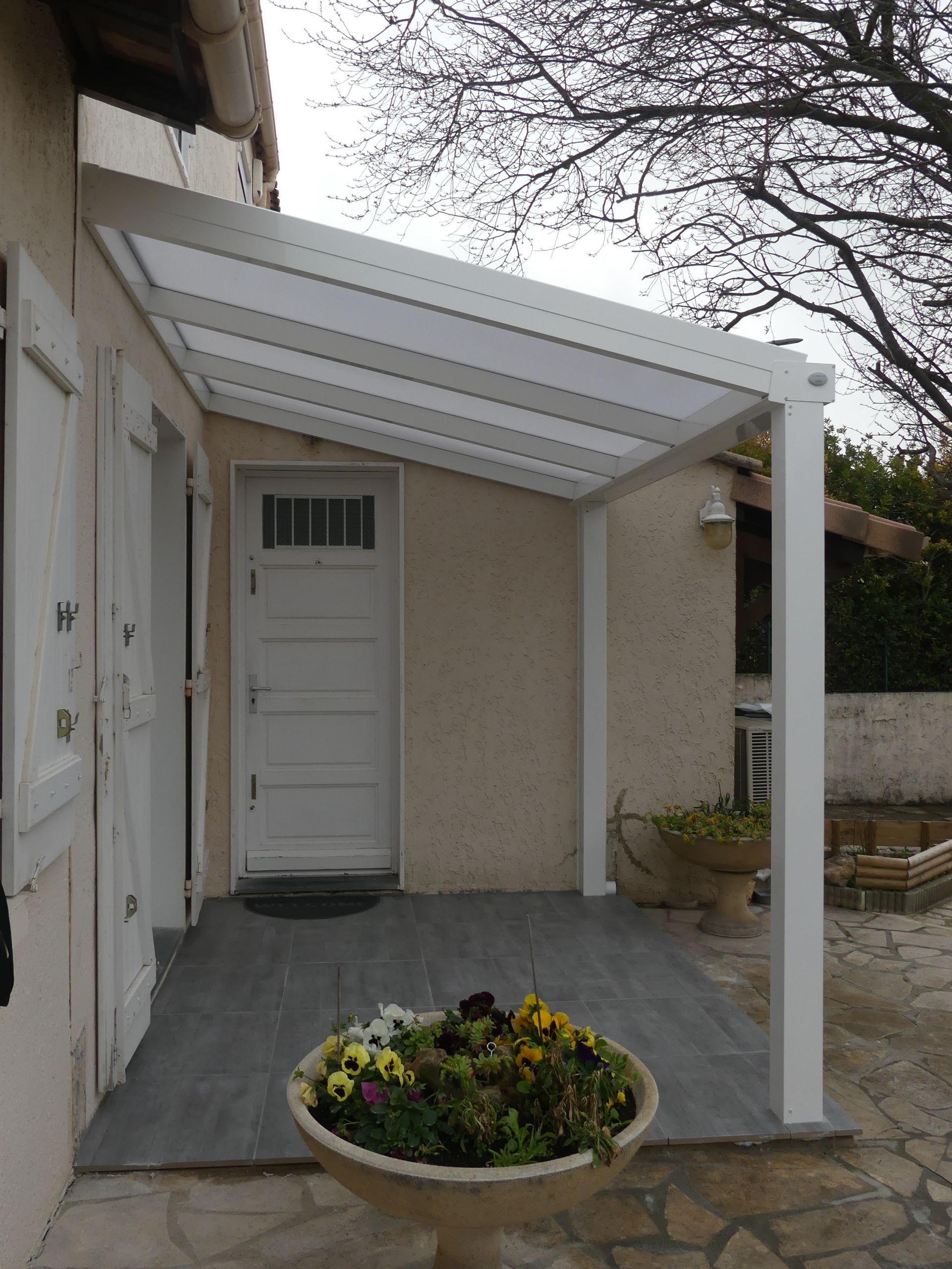 Porte d'entrée sous un auvent blanc