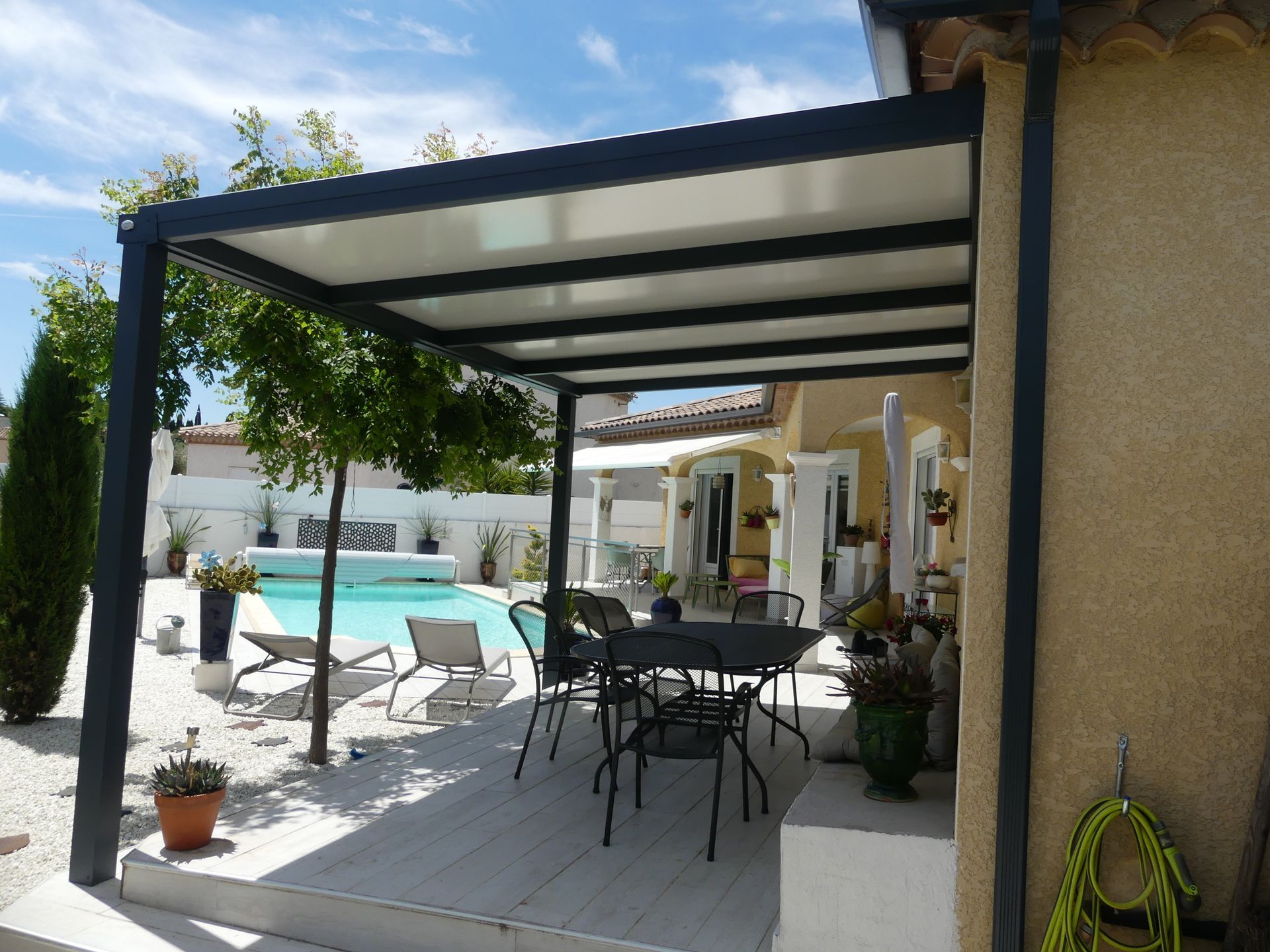 Terrasse sous une pergola au bord d'une piscine
