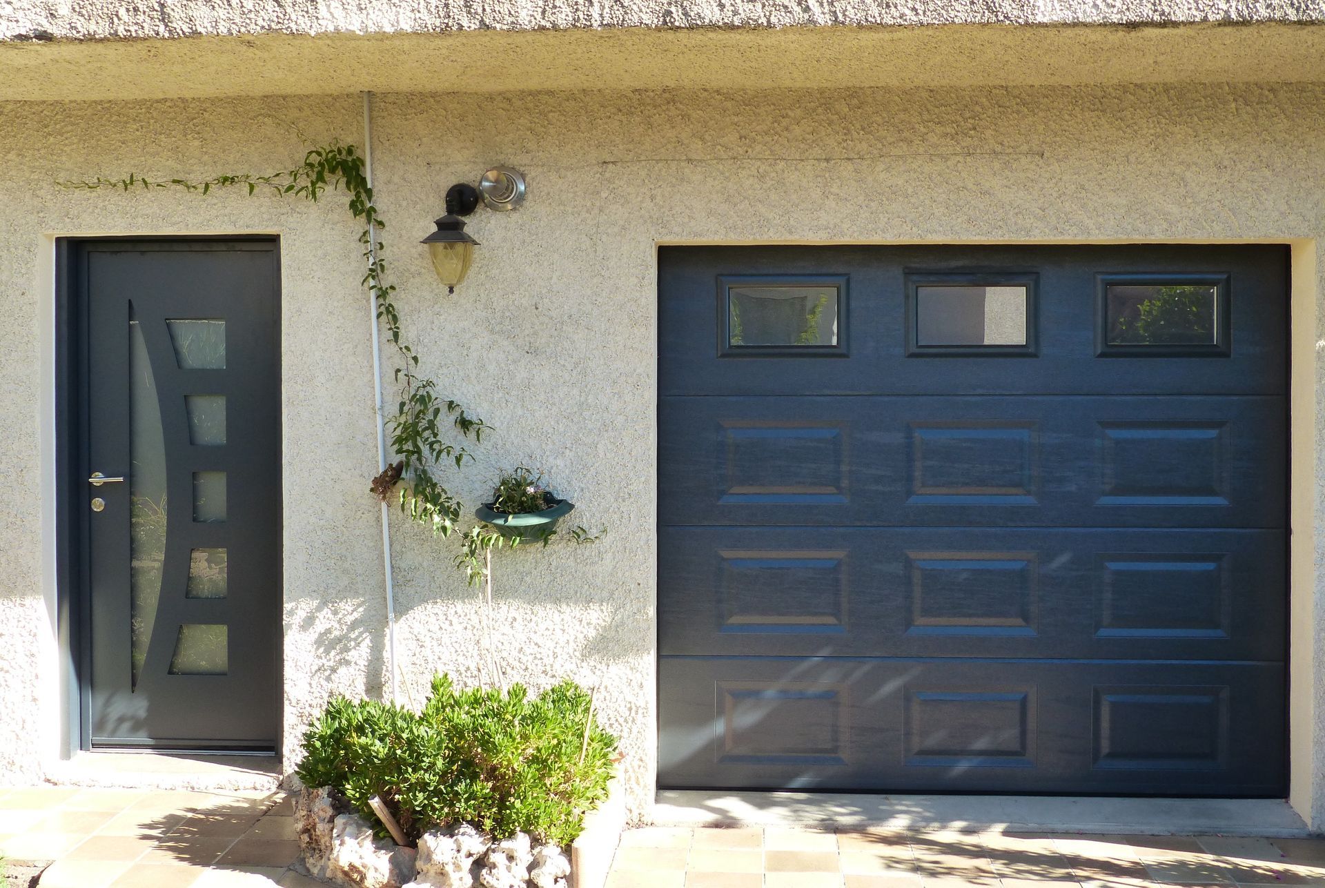 Porte d'entrée et porte de garage bleu sombre d'une habitation