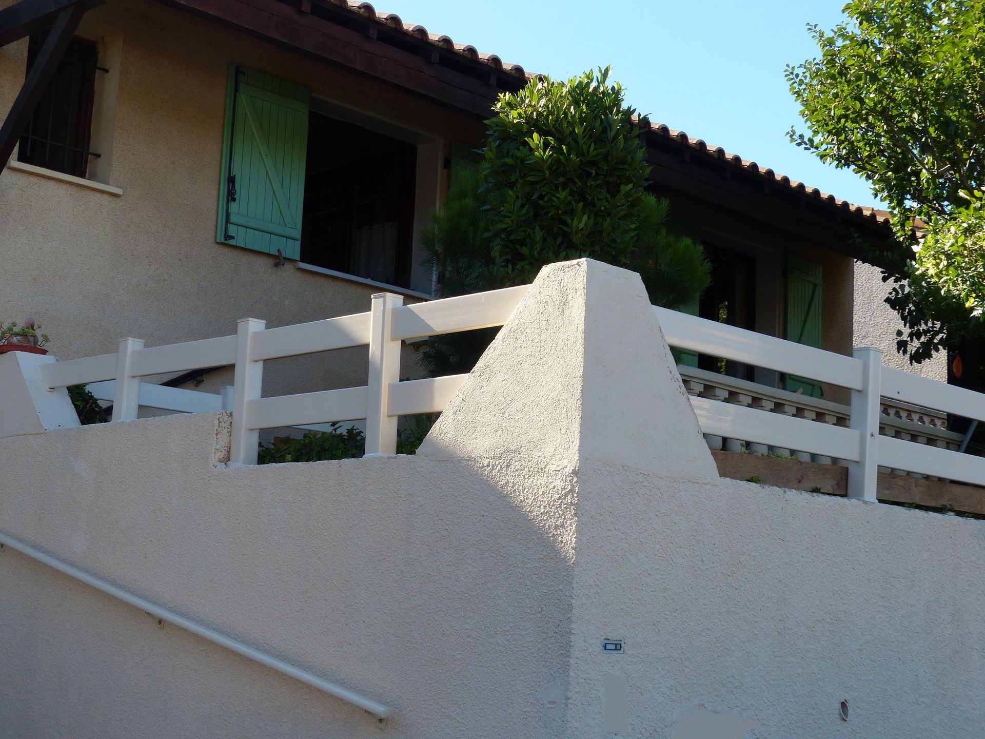 Angle d'un muret avec une rambarde blanche