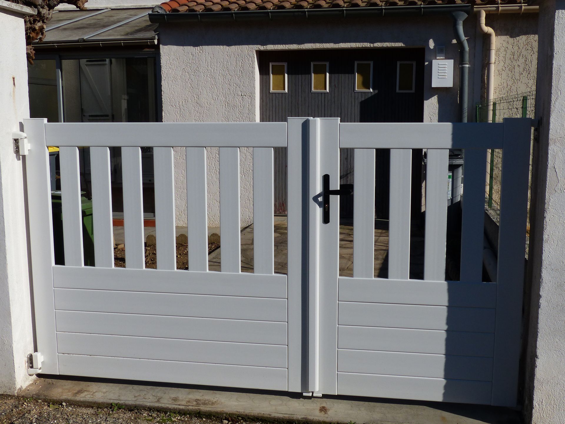 Portail blanc avec un accès via un portillon 