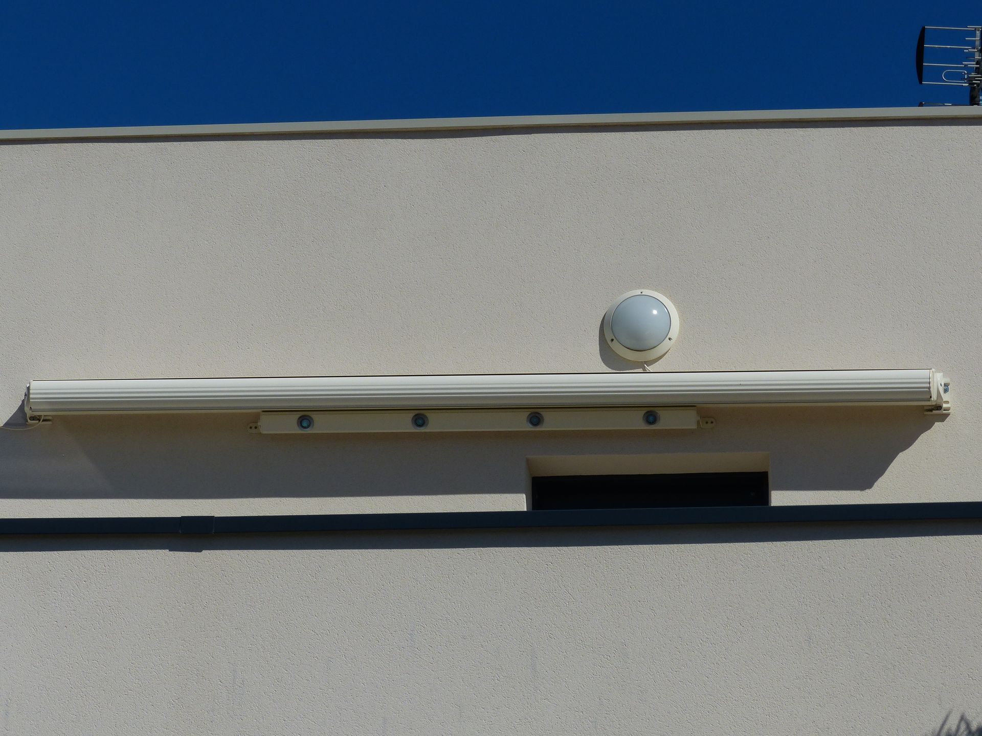 Store extérieur fermé sous un éclairage de façade