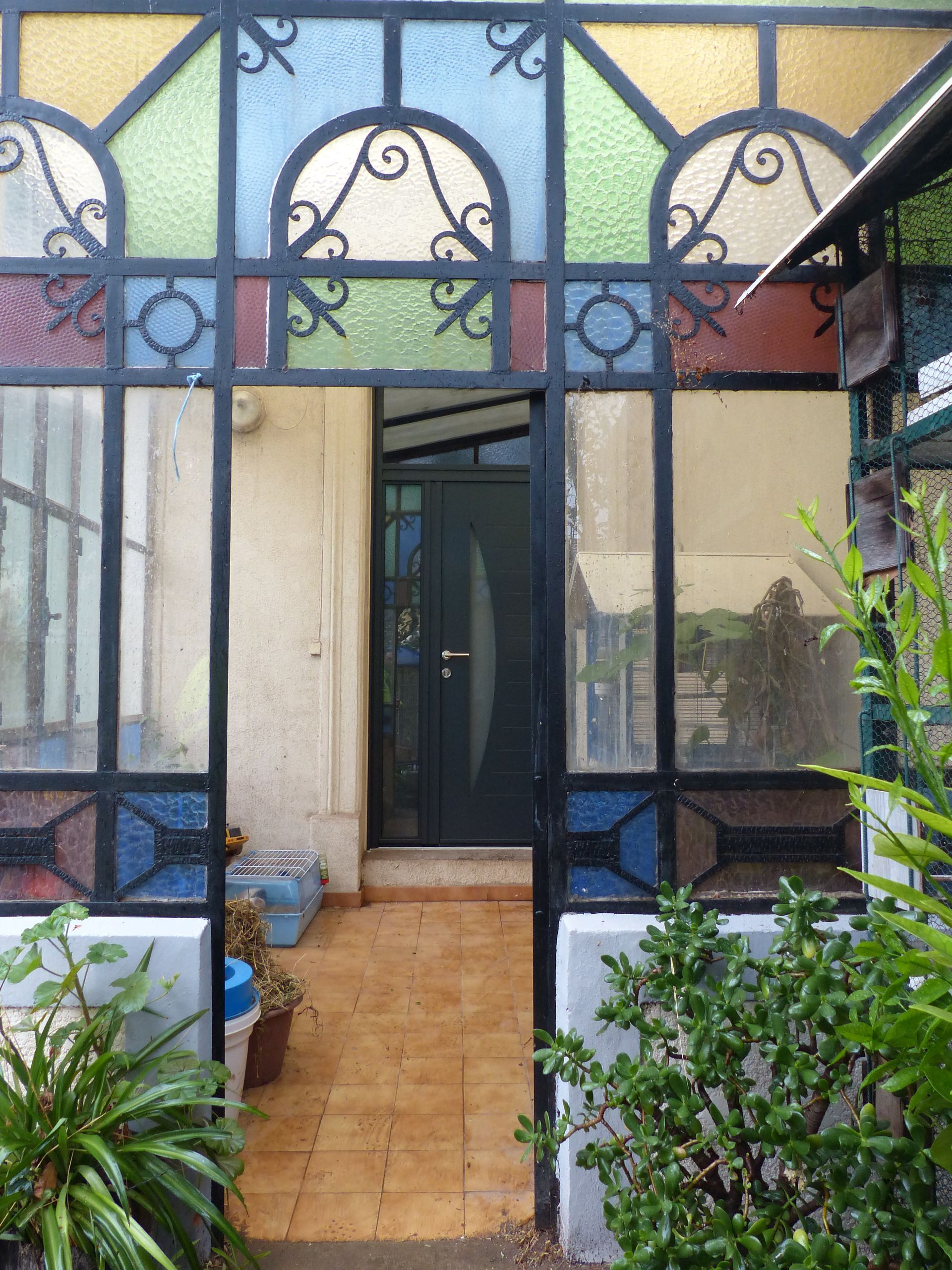 Porte d'entrée gris anthracite d'une maison à l'intérieur d'une véranda