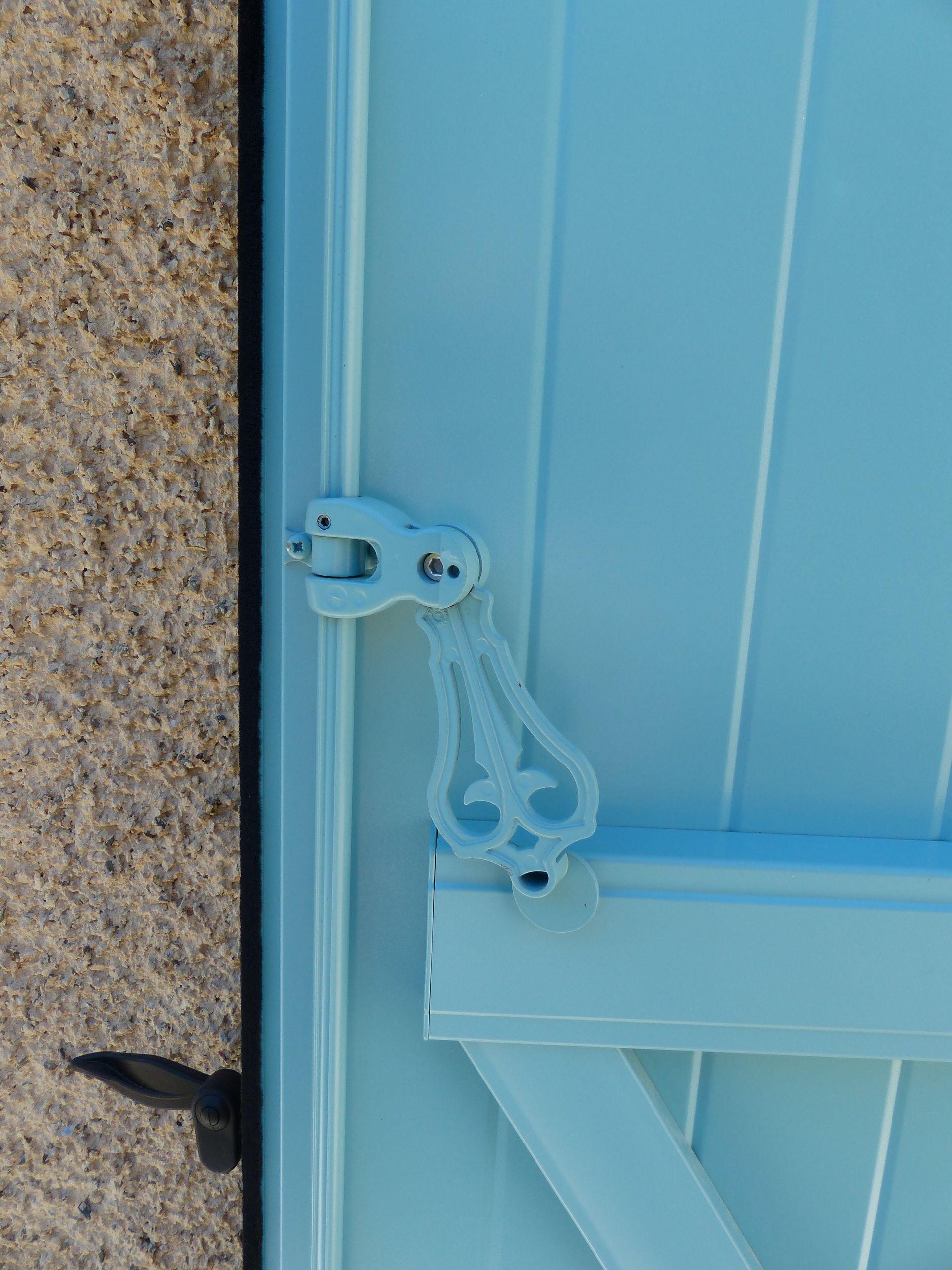 Gros plan de la fixation d'un volet battant de couleur bleu