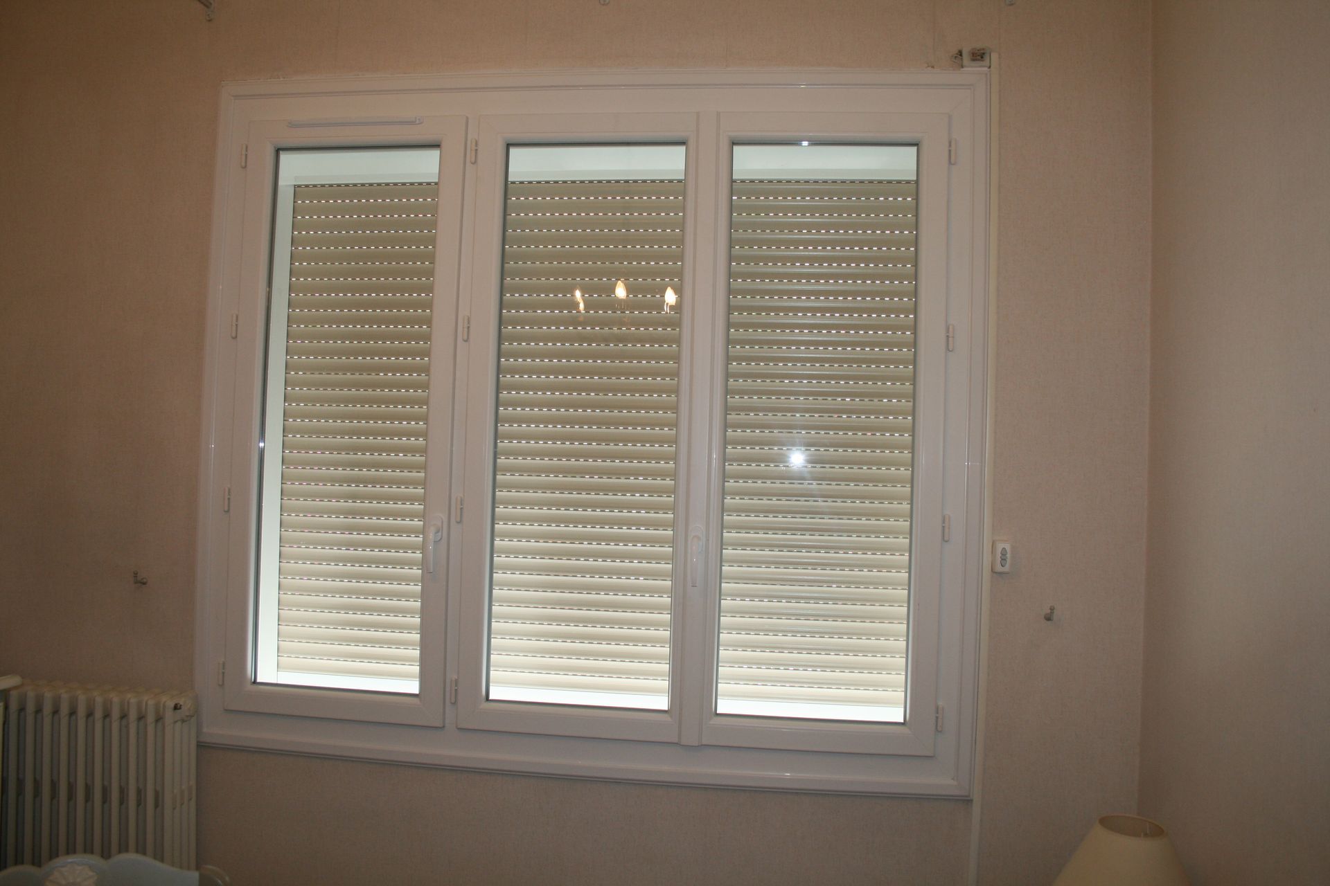 Volet roulant fermé d'une fenêtre à trois vitres 