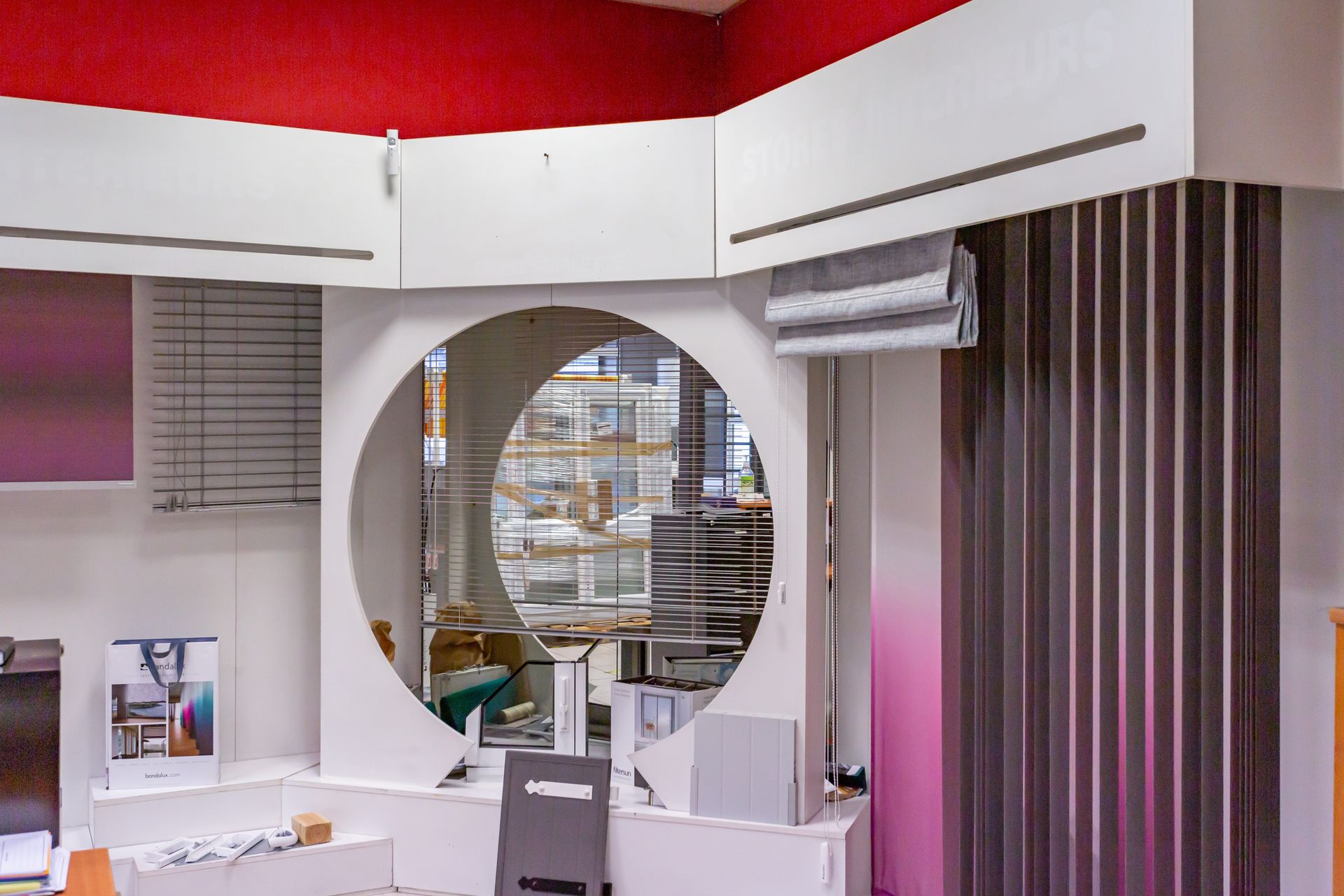 Vue de l'accueil sur l'atelier de menuiserie à travers une ouverture à la forme ronde