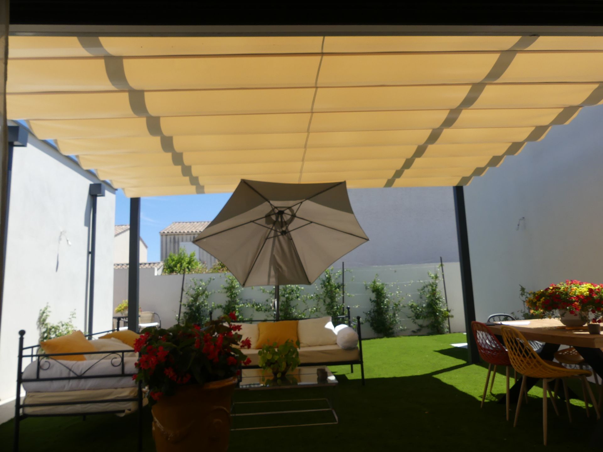 Terrasse au gazon synthétique sous une pergola en toile
