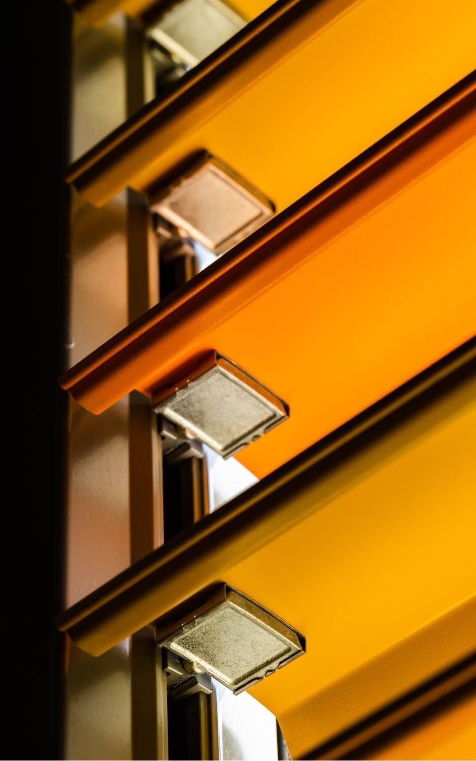 Dettaglio architettonico arancione e argento con luci rettangolari, a strati.
