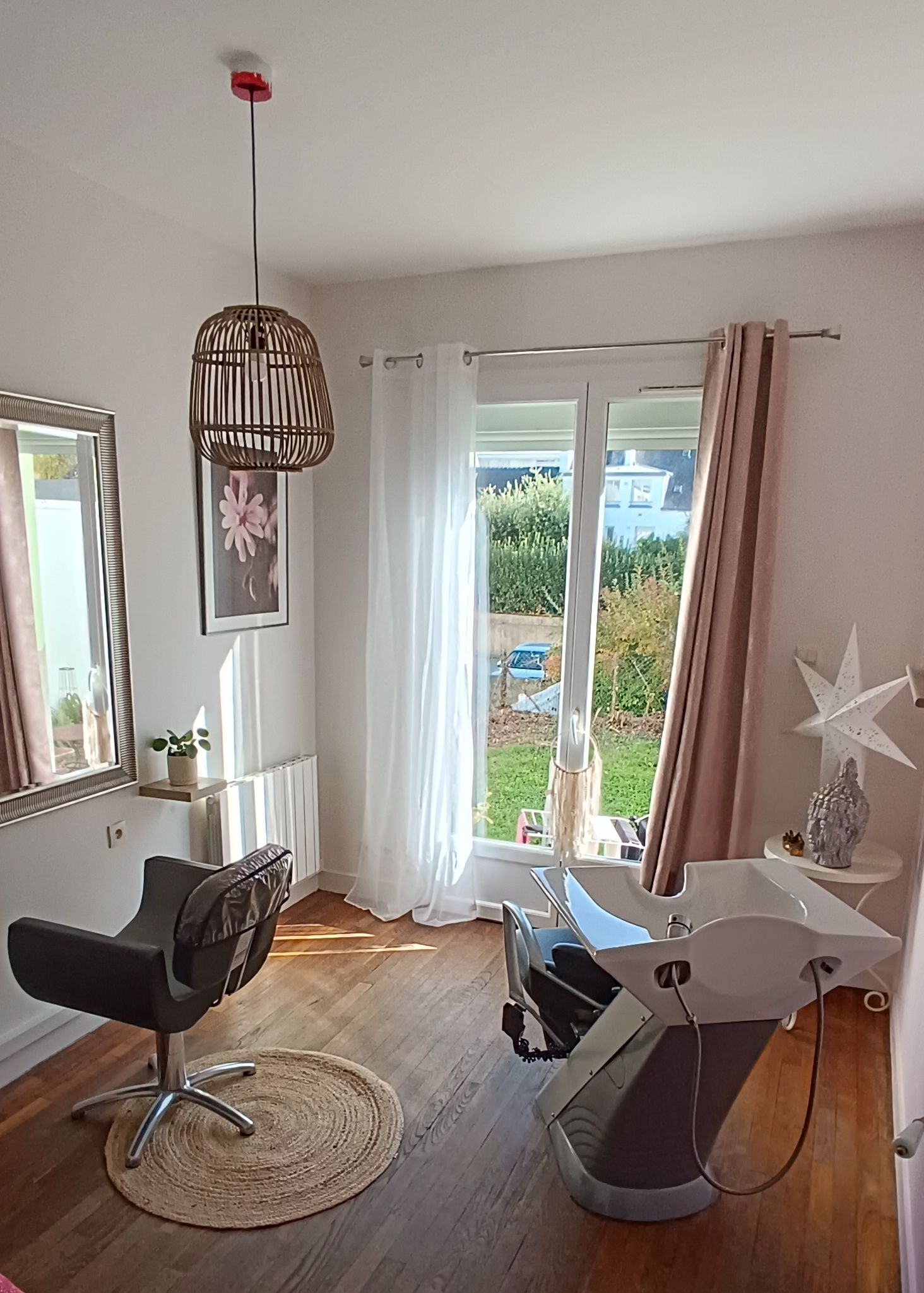 Salon de coiffure avec un fauteuil et un miroir à gauche, un bac à shampoing à droite