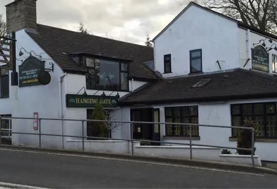 White pub building, the Beaumont Arms, with dark roof and large sign.