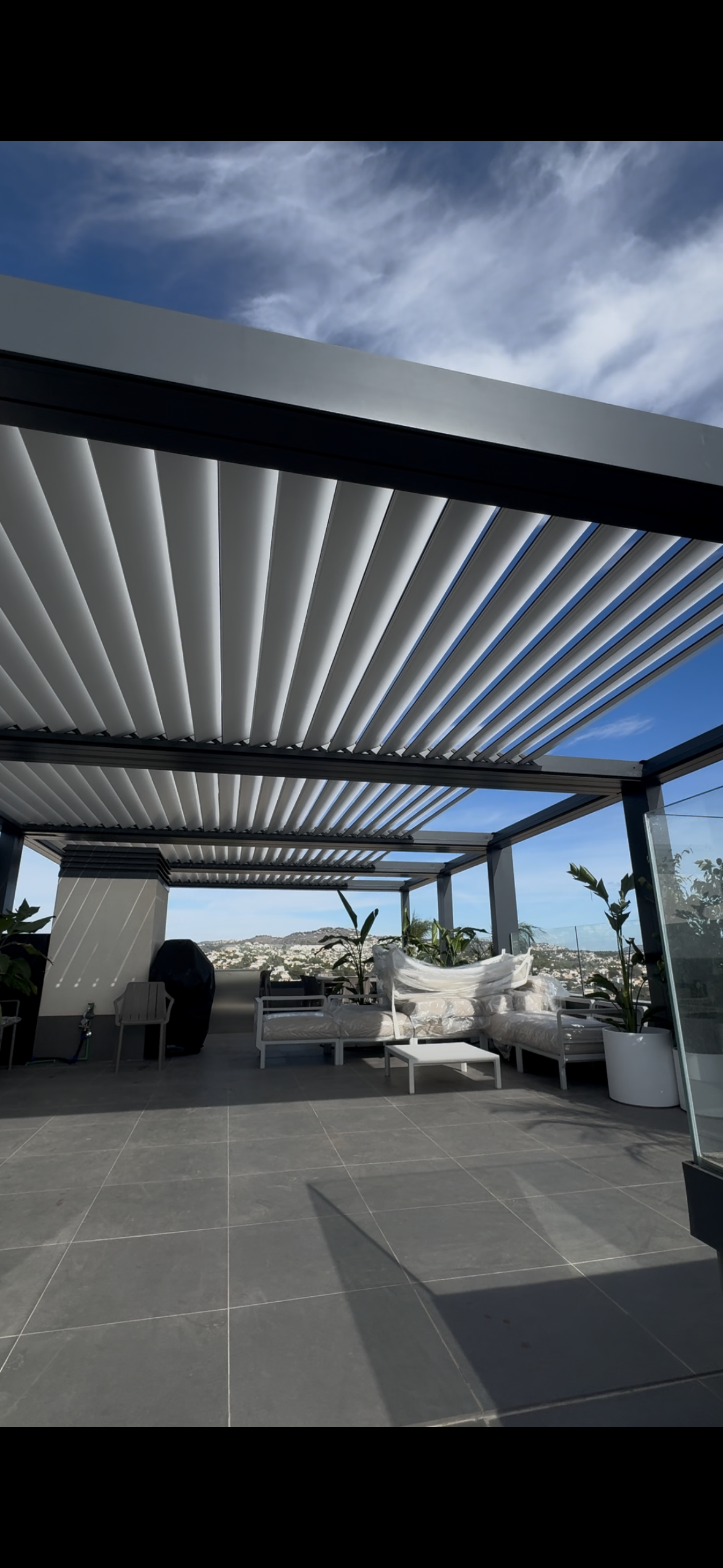 Un rollo de persianas de bambú cuelga en una pared blanca.