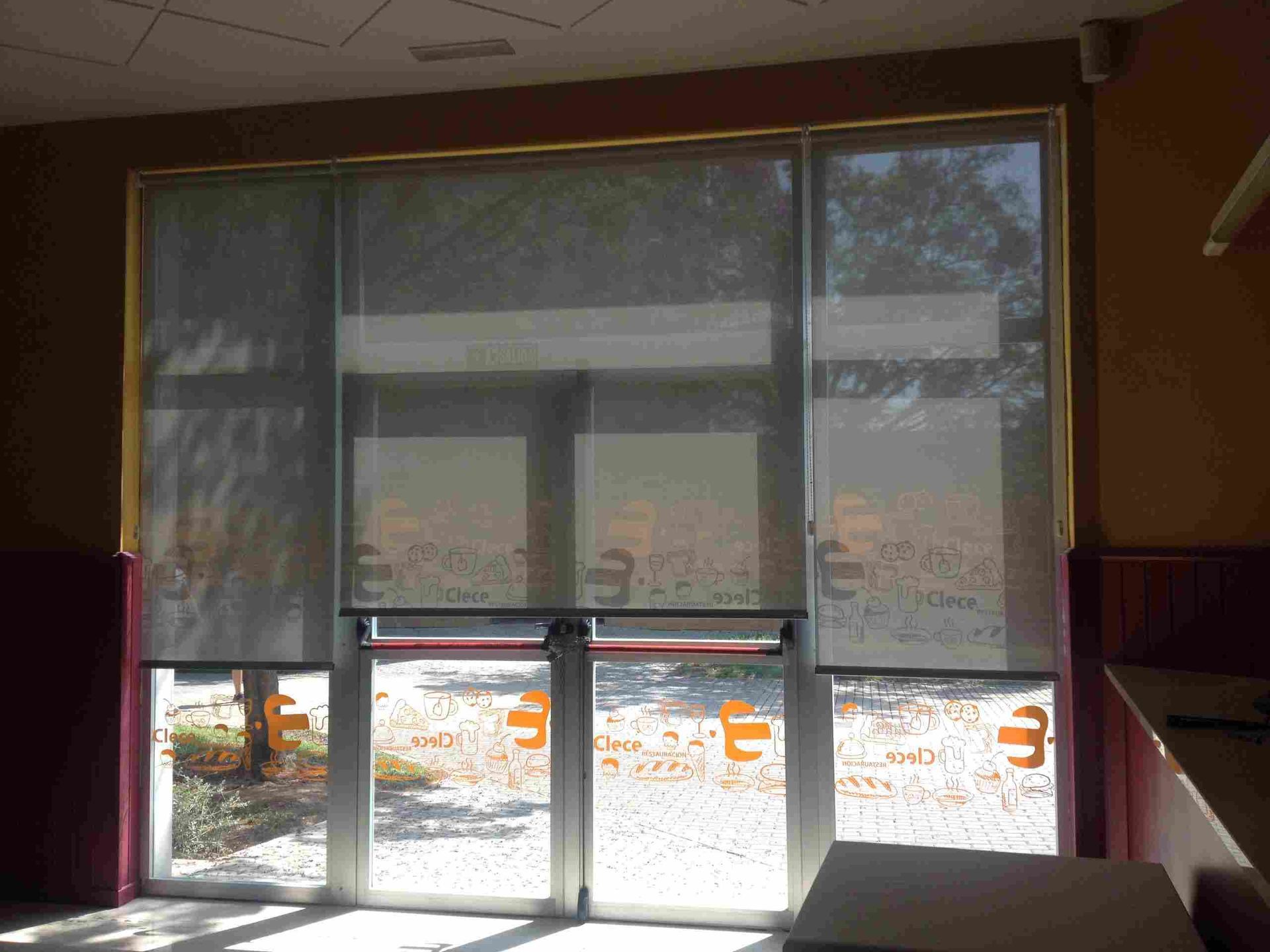 Una habitación con una puerta corrediza de vidrio y persianas en las ventanas.