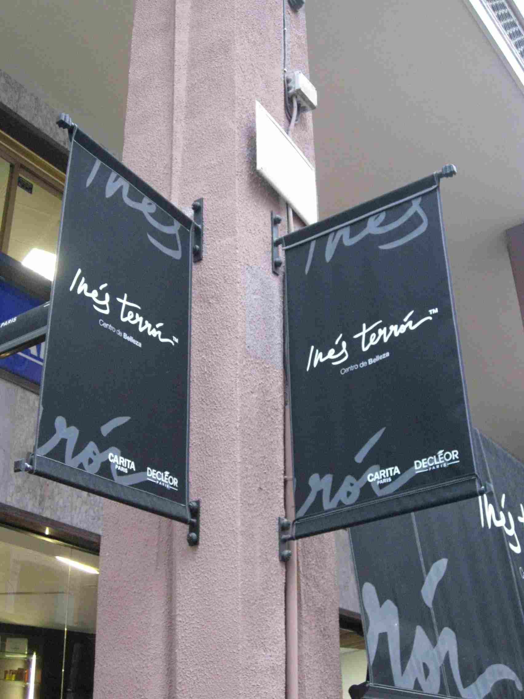 Dos pancartas negras cuelgan de un edificio.