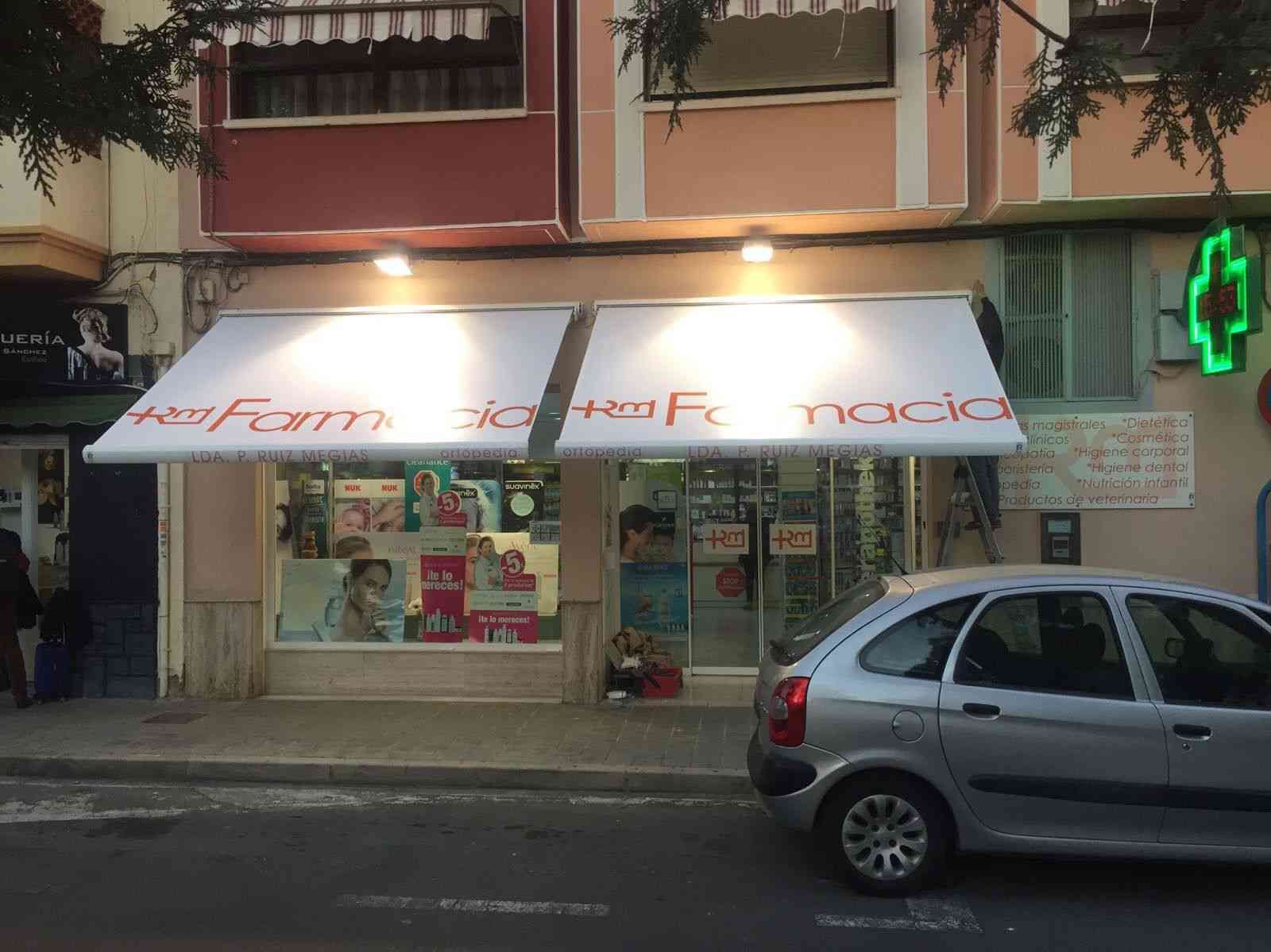 Un coche está aparcado delante de una farmacia.