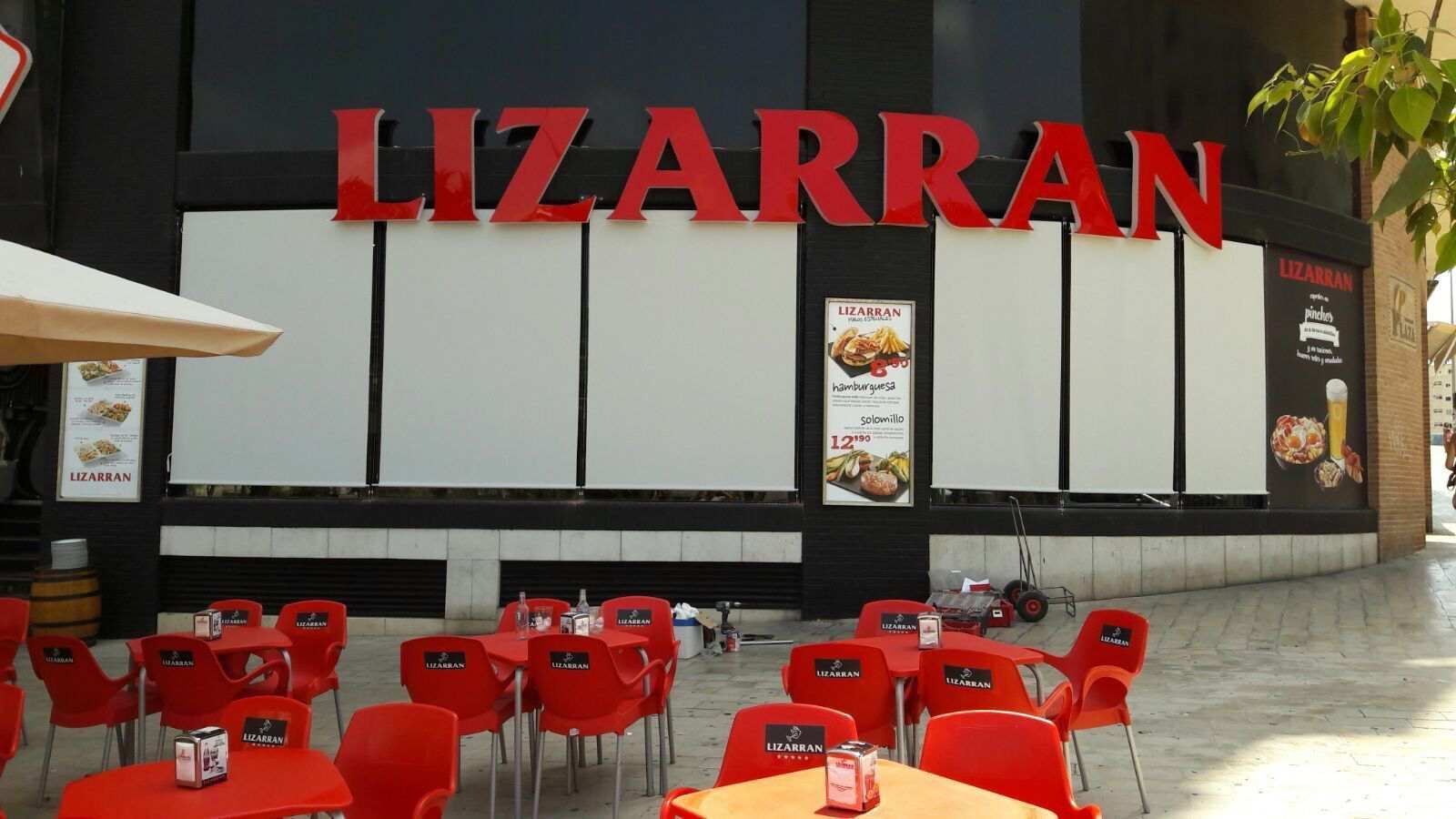 Un restaurante llamado Lizarran tiene mesas y sillas al aire libre.
