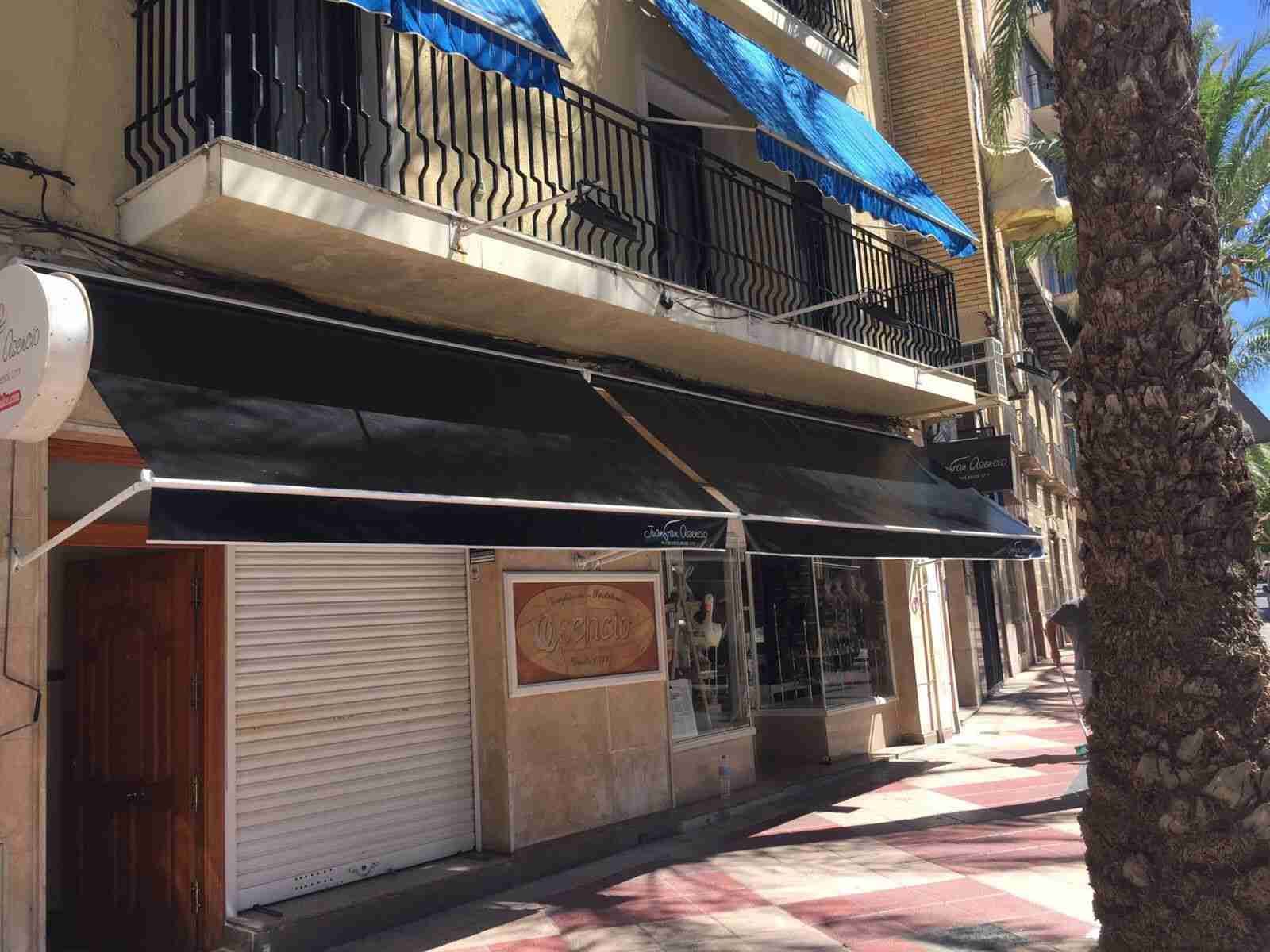 Un edificio con un toldo negro en el costado.