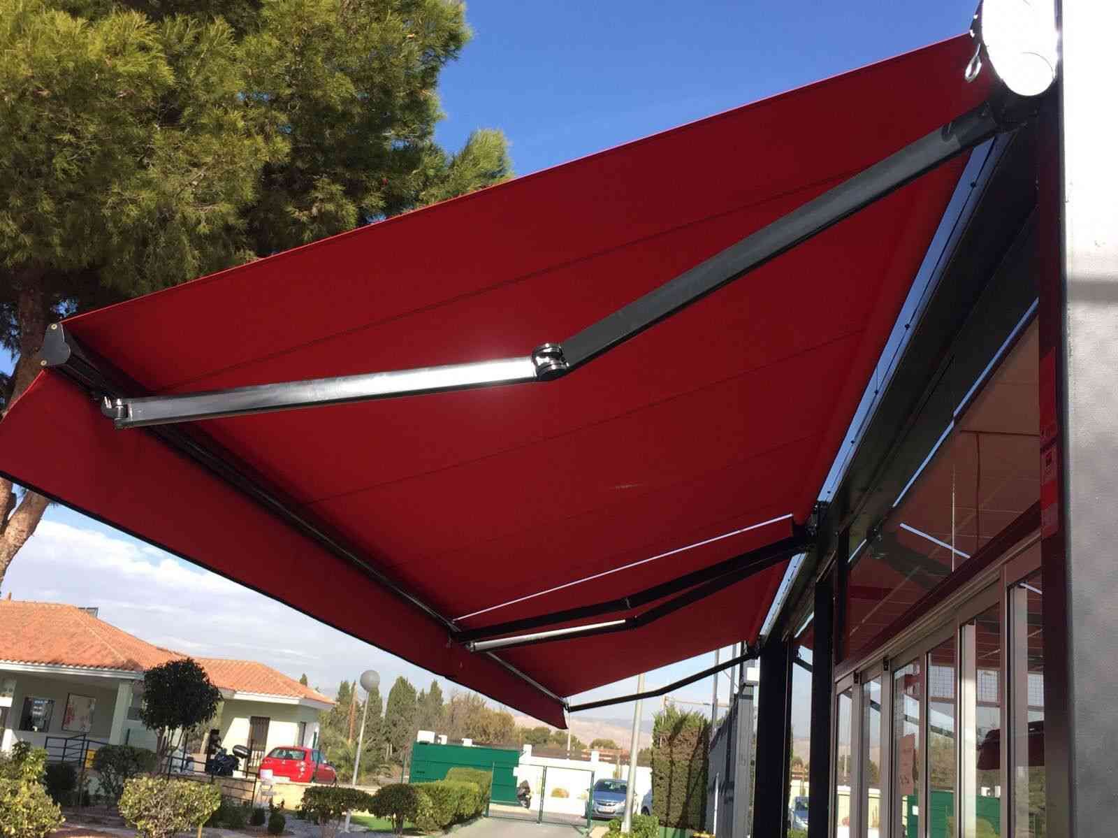 Un toldo rojo cubre el costado de un edificio.